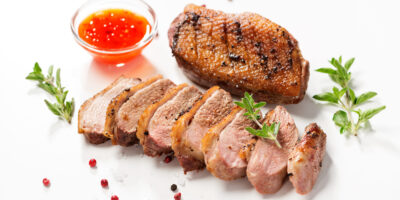 Roasted,Duck,Breast,Served,With,Sauce,And,Fresh,Herbs.,White